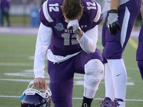 Western Mustangs receiver Brett Ellerman tries to console quarterback Chris Merchant following their 43-40 loss to the Laurier Golden Hawks at the Yates Cup football championship game at TD Stadium on Saturday. (CRAIG GLOVER, The London Free Press)