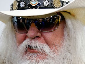 In this Jan. 29, 2013, file photo, reporters are reflected in the sunglasses of Leon Russell as he answers a question at a news conference in Tulsa, Okla. (AP Photo/Sue Ogrocki, File)
