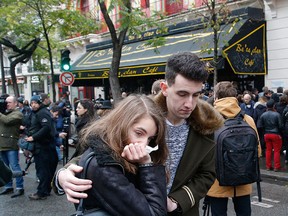 People console each at the Bataclan concert hall in Paris, Sunday, Nov. 13, 2016.  (AP Photo/Michel Euler)