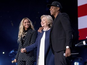 In this Nov. 4, 2016 photo, Democratic presidential candidate Hillary Clinton, center, appears on stage with artists Jay Z, right, and Beyonce during a free concert at at the Wolstein Center in Cleveland. (AP PHOTO)