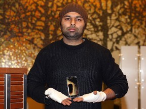 Amarjit Mann holds the Samsung S7 phone, which he says spontaneously combusted on him, causing second- and third-degree burns to his hands, in the lobby of Seven Oaks Hospital in Winnipeg on Sun., Nov. 13, 2016. (Kevin King/Winnipeg Sun/Postmedia Network)