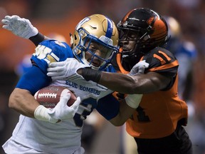 Winnipeg Blue Bombers' Andrew Harris, left, is brought down by B.C. Lions' Mike Edem after rushing for a first down during first half western semifinal CFL football action in Vancouver, B.C., on Sunday November 13, 2016. THE CANADIAN PRESS/Darryl Dyck