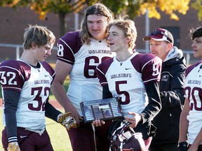 Wallaceburg Tartans captains Dylan Hiltz, left, Camden Fischer, Tanner Cole and Brodie Genyn receive the LKSSAA 'AA' junior football championship plaque from Tom Peel on Saturday at Wallaceburg District Secondary School. (DAVID GOUGH/Postmedia Network)