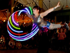 Luke Hendry/The Intelligencer
Erin Ball from Kingston Circus arts whirls an LED-equipped hula hoop while balancing on the feet of Chris Stroesser during the Firelight Lantern Festival Saturday at the Crystal Palace in Picton.