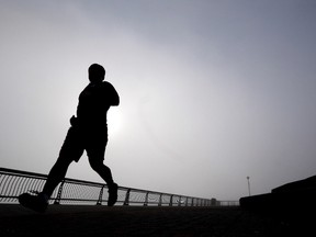 In this Wednesday, Jan. 15, 2014 file photo, a man jogs at Pier A Park in Hoboken, N.J. Clean living can greatly lower your risk for heart disease even if your genes are heavily stacked against you. A large international study released on Sunday, Nov. 13, 2016 found that people with the highest levels of inherited risk cut their chances of suffering a heart attack or other heart problems in half if they didn't smoke, ate well, exercised and stayed slim. (AP Photo/Julio Cortez, File)