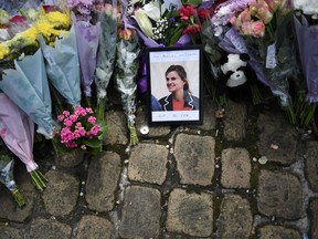 This file photo taken on June 18, 2016 shows a photograph of slain Labour MP Jo Cox sitting amongst flowers left in tribute to her in Birstall, northern England, on June 18, 2016, following her murder on June 16. The trial of the man accused of murdering Labour MP Jo Cox was set to start on November 14. Thomas Mair is accused of murdering the 41-year-old outside her constituency surgery in Birstall, northern England, on June 16. (OLI SCARFF/AFP/Getty Images)