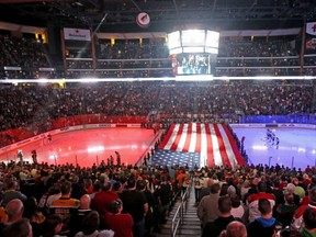 Military personnel display an American flag on the ice for the national anthem on Military Night prior to an NHL hockey game between the Arizona Coyotes and the Boston Bruins Saturday, Nov. 12, 2016, in Glendale, Ariz. (AP Photo/Ross D. Franklin)
