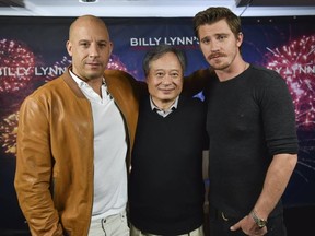 Actors Vin Diesel (L) and Garrett Hedlund with director Ang Lee (C) attend the "Billy Lynn's Long Halftime Walk" photo call on October 15, 2016 in New York City. / AFP PHOTO / ANGELA WEISSANGELA