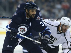 Winnipeg Jets defenceman Dustin Byfuglien squeezes out Los Angeles Kings forward Dwight King during Sunday afternoon's game. (Kevin King/Winnipeg Sun)