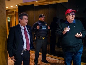 Filmmaker Michael Moore, right, reacts as Secret Service block him to access to restricted areas inside Trump Tower in New York on Saturday, Nov. 12, 2016. During a demonstration, the documentary filmmaker, who is a Trump critic, entered the lobby with a camera crew in tow and asked to see Trump. He was denied. (AP Photo/Andres Kudacki)