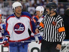 Former Winnipeg Jet Teemu Selanne jokes around with a referee against the Winnipeg Jets Alumni during third-period NHL Heritage Classic Alumni hockey action, in Winnipeg on Oct. 22, 2016. (THE CANADIAN PRESS/John Woods)