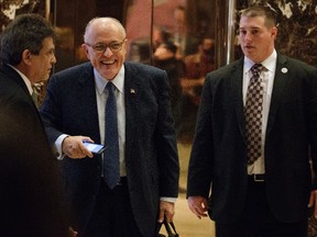 Former New York Mayor Rudy Giuliani, centre, smiles as he leaves Trump Tower, Friday, Nov. 11, 2016, in New York. (AP Photo/Evan Vucci)