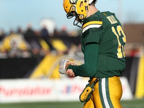 Mike Reilly holds his left wrist while walking off the field Sunday during the East Division semifinal against the Tiger-Cats in hamilton. (The Canadian Press)