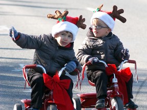 Twins Zack Soares, left, and Rhett Soares, both three and a half, hand out candy as they take part in Wallaceburg's Knights of Pythias Santa Claus parade on Saturday
