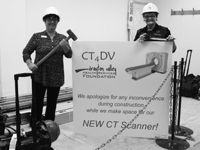 Pictured (l. to r.) Drayton Valley Health Services Foundation Board Chair Mitzi Koebernick holds a sledge hammer while Foundation Development Officer Colleen Sekura holds a tape measure on renovation day for the CT scanner room.