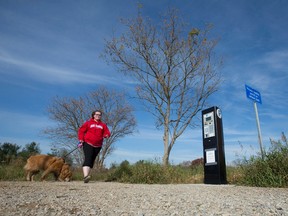 Paige Mol walks her golden retriever Harley past a parking payment machine at the entrance to Komoka Provincial Park in London, Ont. on Tuesday November 15, 2016. Spurred on by complaints from constituents, London-West MPP Peggy Sattler brought up the newly introduced pay-to-park scheme in session at Queens Park this week, urging the Liberal government to reinstitute free parking at the park located west of London. (CRAIG GLOVER, The London Free Press)