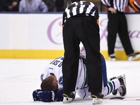 Referee Kelly Sutherland checks on Vancouver Canucks left wing Daniel Sedin, who was hit by Toronto Maple Leafs centre Nazem Kadri  after scoring during third period NHL hockey action in Toronto on Saturday, November 5, 2016. THE CANADIAN PRESS/Frank Gunn