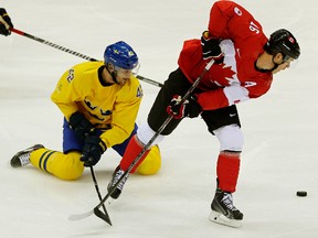 Sweden's Jimmie Ericsson (left) tries to slow down Canada's Jonathan Toews during the first period in the gold medal game at the Bolshoy Ice Dome at the Sochi Winter Olympics in Sochi, Russia, on Feb. 23, 2014. (Al Charest/Postmedia/Files)