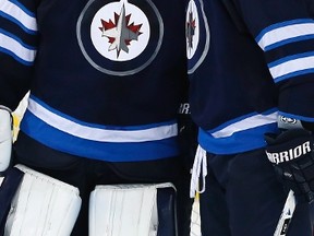 Winnipeg Jets goaltender Connor Hellebuyck and Dustin Byfuglien celebrate Hellebuyck's shutout against the Chicago Blackhawks on Tuesday night. The Jets return to action on Thursday in Philadelphia. (THE CANADIAN PRESS/John Woods)