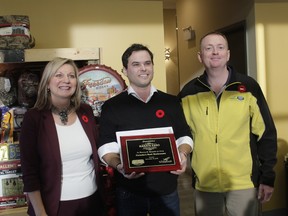 Whitecourt Mayor Maryann Chichak (left) and Woodlands County Mayor Jim Rennie (right) present Whitecourt Esso Super Station owner Landon Hommy (centre) with a plaque recognizing his station for the achievement of winning the Cintas Canada Best Restroom Contest on Nov. 10.