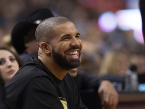 Drake is all smiles while sitting courtside at the Raptors game against the Warriors on Wednesday night. (CRAIG ROBERTSON/Toronto Sun)