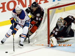 Ryan Nugent-Hopkins takes the puck around the net while being chased by Ducks forward Antoine Vermette Tuesday in Anaheim. (AP Photo)