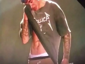 Canadian crooner Justin Bieber wipes away tears on a Metallica T-shirt during a performance of Purpose at a concert in Frankfurt, Germany on Wednesday. (Screen Capture)
