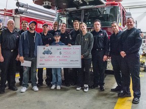 Submitted photo by Adam Burr
Aidan Reil, centre, holds a cheque presented to his family by Quinte West volunteer firefighters at Station 1. Left to right: Ryan Robertson, Brad Graham, Matt Michaud, Wayne Reil, Jeremy Newbery, Eric Bowes, Aidan Reil, Kevin Scott, Joe McCombe, Sarah Grover, Greg Callahan, Chris Baylis, Adam Burr.