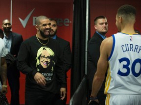 Drake meets up with Golden State Warriors guard Stephen Curry in the tunnel at the ACC after the loss in Toronto on Nov. 16, 2016. (Craig Robertson/Toronto Sun/Postmedia Network)