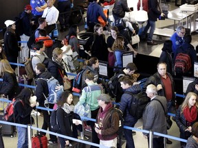 In this Sunday, Nov. 29, 2015, file photo, travellers line up at a security checkpoint area in Terminal 3 at O'Hare International Airport in Chicago. (AP Photo/Nam Y. Huh, File)