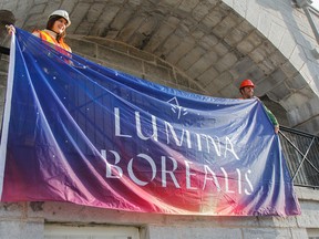 Natalie Bojovia, from Moment Factory, and Greg Gouthro, supervisor-product enrichment with Fort Henry, hold up the newly arrived special flag at Fort Henry on Wednesday that will be flown at the fort throughout the new winter event, Lumina Borealis. The nighttime winter walk event will run from Dec. 1 to Feb. 4. (Julia McKay/The Whig-Standard)