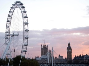 The sun sets beyond the Elizabeth Tower, also known as Big Ben, at the Houses of Parliament, right, and the London Eye, in central London on November 7, 2016. (JUSTIN TALLIS/AFP/Getty Images)