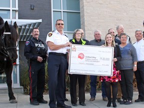 Organizers of the North American Police Equestrian Championships hand over a $20,000 cheque to the United Way of Kingston, Frontenac, Lennox and Addington at Police Headquarters on Wednesday. (Steph Crosier/The Whig-Standard)