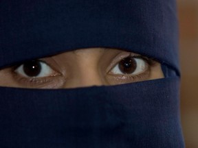 A Muslim woman wearing a niqab, a headdress that essentially covers everything but the eyes, is pictured in this file photo.  (Postmedia Network file photo)