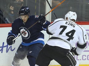 Toby Enstrom (left) and Los Angeles Kings left winger Dwight King fight for the puck during last Sunday's game. (Brian Donogh/Winnipeg Sun file photo)