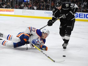 Edmonton Oilers centre Connor McDavid, left, falls as he tries to pass the puck while under pressure from Los Angeles Kings right wing Devin Setoguchi during the third period of an NHL hockey game, Thursday, Nov. 17, 2016, in Los Angeles. The Kings won 4-2.