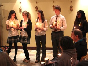 Caleb Stringer, second from right, takes part in the candlelight vigil he organized at Regiopolis-Notre Dame Catholic High School in Kingston on Friday to bring attention to the issue of mental illness. (Michael Lea/The Whig-Standard)