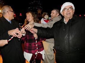 Emily Mountney-Lessard/The Intelligencer 
Mayor Taso Christopher (left) and councillor Garnet Thompson (far right) are joined by Kathy-Lyn Best, her husband Bill and baby Joshua who assisted with the Christmas light display ceremony in Jane Forrester Park near Meyers Pier on Friday.
