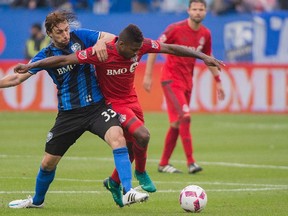 Montreal Impact’s Marco Donadel (left), seen here with Toronto FC’s Armando Cooper, says the Reds better bring their ‘A’ game. (The Canadian Press)