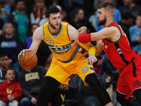 Denver Nuggets’ Jusuf Nurkic (left) looks to pass the ball as Raptors’ Jonas Valanciunas defends on Friday night at the Pespi Center in Denver. (AP/PHOTO)