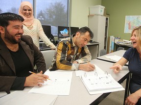 Jana McKee  shares a light moment with (l-r) Ahmad Alghazawy, Noor Barem and Sameer Alzoupi during an English class at Seven Oaks Adult Learning Centre. McKee and Noor have been among those responsible for helping Syrian refugees get acclimated to their new lives over the past year. Brian Donogh/Winnipeg Sun/Postmedia Network