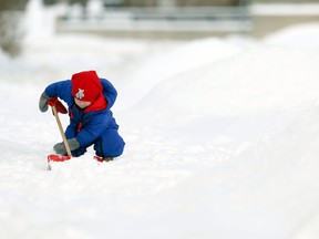 Young Murphy O'Brien helps his dad, Sean, clean up after a heavy snowfall in Ottawa Sunday February 2, 2014. Darren Brown, Postmedia