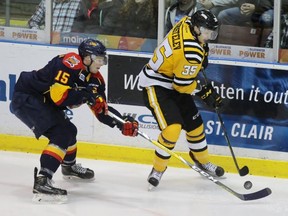 Erie Otters captain Kyle Pettit and Sarnia Sting forward Nikita Korostelev reach for the puck during the Ontario Hockey League game at Progressive Auto Sales Arena on Saturday, Nov. 19, 2016 in Sarnia, Ont. Erie won 4-3 with a late power-play goal. Terry Bridge/Sarnia Observer/Postmedia Network