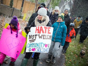 Six year old Arden Khan along with her mom Tabitha Bernard were wearing some community solidarity signs while taking part in the march on Sunday against racism, Nov. 20 2016.  Ashley Fraser, Postmedia