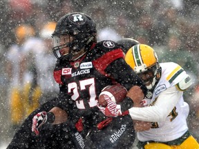 Eskimos DB Brandyn Thompson tackles RedBlacks running back Kienan Lafrance during the first half of the East Division final Sunday in Ottawa. (The Canadian Press)