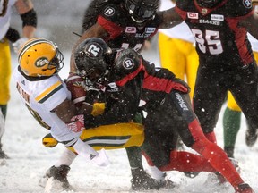 Eskimos receiver Cory Watson is tackled by RedBlacks DE Abdul Kenneh during Sunday's game in Ottawa. (The Canadian Press)