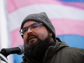 The Transgender Pride flag flaps in the wind behind Trans Equality Society of Alberta past president Jan Buterman, during a ceremony to raise the flag at the Alberta Legislature grounds in remembrance of those whose lives have been lost due to transphobia, hatred or prejudice, in Edmonton on Sunday Nov. 20, 2016. Photo by David Bloom