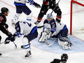 Victor Rask shoots the puck past Blake Wheeler (26) and goalie Connor Hellebuyck during the third period on Sunday. (AP Photo/Karl B DeBlaker)