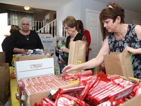 Liz Herd creates a Christmas gift bag at  her home  in Hanmer on Sunday. Herd and her team of friends, family and colleagues  stuffed Christmas gift bags Sunday at her home for people in psychiatric wards, on the street or who are clients at 127 Cedar St. (Gino Donato/Sudbury Star)
