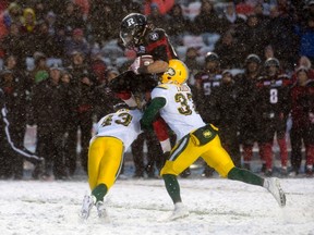 Kienan Lafrance leaps to avoid a pair of Eskimos tacklers during Sunday's game in Ottawa. (The Canadian Press)